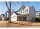 Two-story house with beige siding, a white garage door, and a landscaped yard at 311 Tuggle Ct, Woodstock, GA 30188