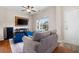 Cozy living room featuring a gray sofa, a large TV, and hardwood floors at 311 Tuggle Ct, Woodstock, GA 30188