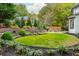 Landscaped backyard with circular lawn and stone retaining walls at 3214 Burnette Ne Dr, Roswell, GA 30075