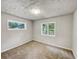Bright bedroom with neutral carpeting and two windows at 170 Pinehurst Dr, Stockbridge, GA 30281