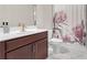 Bathroom features a single vanity with dark wood cabinets and decorative shower curtain at 4259 Hansford Loop, Marietta, GA 30064