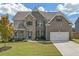 Charming two-story brick and stone home with a two-car garage, lush lawn and professional landscaping at 4259 Hansford Loop, Marietta, GA 30064