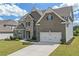 Stunning two-story brick home with a two-car garage, well-manicured lawn, and walkway to the front door at 4259 Hansford Loop, Marietta, GA 30064