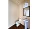 Simple, newly remodeled bathroom with pedestal sink and dark wood flooring at 5150 Amberland Sq, Atlanta, GA 30349