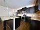 Modern kitchen with dark cabinetry, granite counters, and island at 5150 Amberland Sq, Atlanta, GA 30349