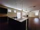 Open concept kitchen with island and view to living room at 5150 Amberland Sq, Atlanta, GA 30349