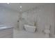 Elegant bathroom with freestanding tub, marble tile, and gold fixtures at 2036 E Camellia Dr, Decatur, GA 30032