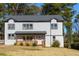 Two-story white house with gray roof, wooden porch, and landscaped yard at 2036 E Camellia Dr, Decatur, GA 30032