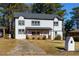 Two-story white house with gray roof, wooden porch, and landscaped yard at 2036 E Camellia Dr, Decatur, GA 30032