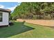 A view of a backyard with well-maintained green grass, a privacy fence, and tall, mature trees at 334 Spotted Ridge Cir, Woodstock, GA 30188