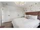 Stylish bedroom features a tufted headboard, floral wallpaper, modern lighting, and hardwood floors at 334 Spotted Ridge Cir, Woodstock, GA 30188