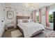 Charming bedroom boasts a plush bed, floral wallpaper, a sparkling chandelier, and light pink window coverings at 334 Spotted Ridge Cir, Woodstock, GA 30188