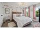 Charming bedroom with light wood floors, pink accents, a comfortable bed, and lots of natural light at 334 Spotted Ridge Cir, Woodstock, GA 30188