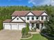 Stunning traditional home showcasing a three car garage, brick facade, and well-maintained landscaping at 334 Spotted Ridge Cir, Woodstock, GA 30188