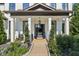 Inviting front porch with columns, lush landscaping, and a stylish door at 334 Spotted Ridge Cir, Woodstock, GA 30188