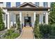 Charming front porch featuring classic columns, neat landscaping and an inviting black front door at 334 Spotted Ridge Cir, Woodstock, GA 30188