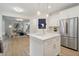 Open concept kitchen features a marble island, stainless steel refrigerator, and modern fixtures at 334 Spotted Ridge Cir, Woodstock, GA 30188