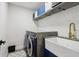 The laundry room boasts modern front-loading machines, a farmhouse sink, and stylish storage at 334 Spotted Ridge Cir, Woodstock, GA 30188