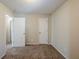 Simple bedroom with carpet and doors to hallway at 7618 Mcgillicuty Dr, Union City, GA 30291