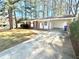 Charming brick home with a covered carport and a well-maintained front yard and a concrete driveway at 869 Meadow Rock Way, Stone Mountain, GA 30083