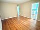 Spacious living room showcasing gleaming hardwood floors, leading to an adjacent kitchen with blue walls at 869 Meadow Rock Way, Stone Mountain, GA 30083