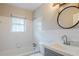 Updated bathroom with white tiled walls, gray vanity, and a bathtub at 2756 Plantation Dr, East Point, GA 30344