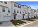 Exterior view of townhomes with white siding, black accents, and attached garages at 3170 Washburn Sw St, Atlanta, GA 30354