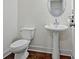 Small powder room with pedestal sink and dark wood floors at 7628 Squire Court, Fairburn, GA 30213