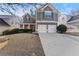 Two-story house with gray siding, two-car garage, and landscaped yard at 449 Highlands Loop, Woodstock, GA 30188