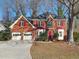 Brick house with two-car garage and landscaped lawn at 1499 Justin Dr, Lawrenceville, GA 30043