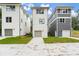 Three-story townhouses, two white and one gray, featuring attached garages and front yards at 1695 Thomas St, Decatur, GA 30032