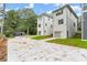 Rear view of three townhouses showcasing attached garages and a shared concrete driveway at 1695 Thomas St, Decatur, GA 30032