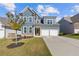 Two-story home with a two-car garage and a green door at 711 Bridgeview Dr, Holly Springs, GA 30115