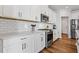 Modern kitchen with white cabinets, quartz countertops, and stainless steel appliances at 711 Bridgeview Dr, Holly Springs, GA 30115