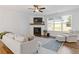 Cozy living room with a fireplace, hardwood floors, and large windows at 711 Bridgeview Dr, Holly Springs, GA 30115