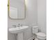 Modern powder room with pedestal sink and gold mirror at 711 Bridgeview Dr, Holly Springs, GA 30115