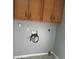 Laundry closet with wood cabinets and gray walls at 8374 Carlton Rd, Riverdale, GA 30296