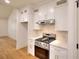 White kitchen with stainless steel appliances and hardwood floors at 1947 Clark Dr, Tucker, GA 30084