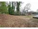 Wide shot of backyard with trees and an overgrown lot at 649 Ozburn Nw Rd, Atlanta, GA 30318