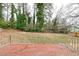 View of the backyard from the old cracked brick patio overlooking overgrown shrubs and various trees at 649 Ozburn Nw Rd, Atlanta, GA 30318