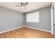 This bedroom features a ceiling fan, neutral paint, and wood-look laminate flooring at 649 Ozburn Nw Rd, Atlanta, GA 30318