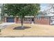 Charming brick home with a large tree in the front yard and a well-manicured lawn at 649 Ozburn Nw Rd, Atlanta, GA 30318
