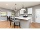 Modern kitchen with white cabinetry, quartz countertops, stainless steel appliances, and island seating at 649 Ozburn Nw Rd, Atlanta, GA 30318