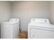 Bright laundry area with white washer and dryer for household convenience at 649 Ozburn Nw Rd, Atlanta, GA 30318