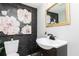 Stylish powder room featuring a modern vanity, floral wallpaper and an elegant framed floral print at 649 Ozburn Nw Rd, Atlanta, GA 30318