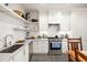 White kitchen with stainless steel appliances and open shelving at 10625 Serenbe Ln # 103, Chattahoochee Hills, GA 30268