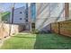 Private backyard with artificial grass, a wooden fence, and a view of the home's modern exterior at 1412 Peter Haughton Nw Way, Atlanta, GA 30318