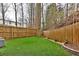 Expansive backyard featuring artificial grass, a wooden fence, and mature trees along the property line at 1412 Peter Haughton Nw Way, Atlanta, GA 30318