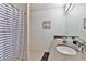 Tiled bathroom featuring double sinks, mirror, and a striped shower curtain at 1412 Peter Haughton Nw Way, Atlanta, GA 30318