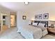 Bright bedroom with neutral carpet, white walls, and view to a bathroom with striped shower curtain at 1412 Peter Haughton Nw Way, Atlanta, GA 30318